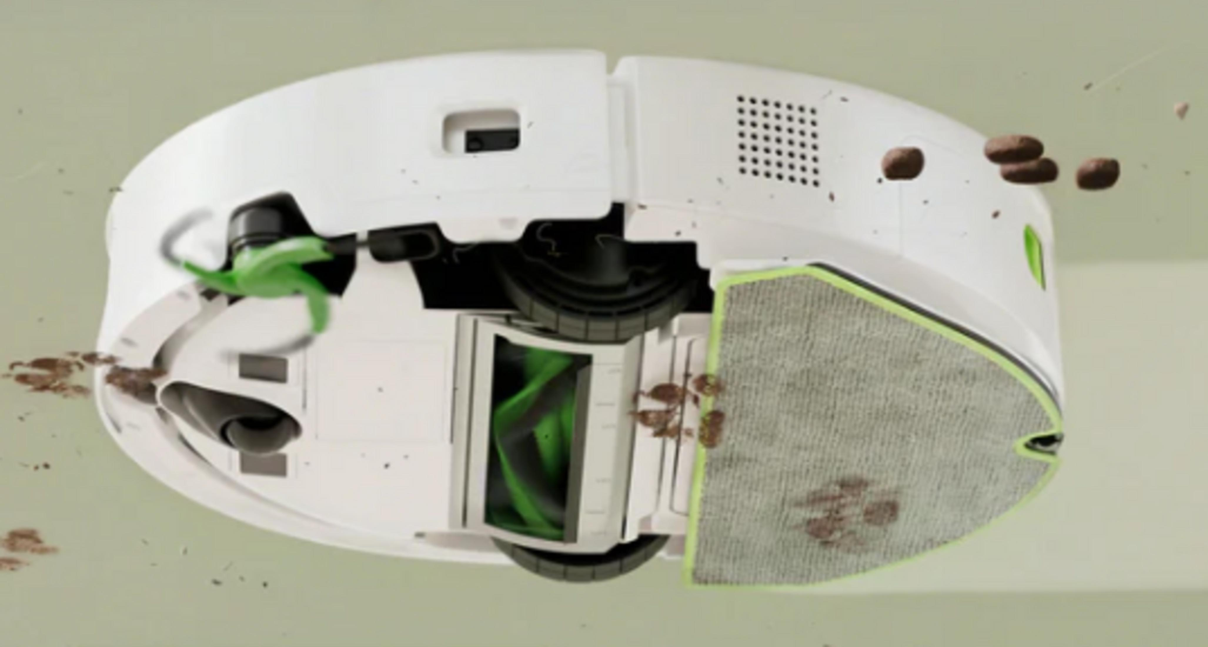 Un robot aspirapolvere bianco con accenti verdi, che solleva sporco.