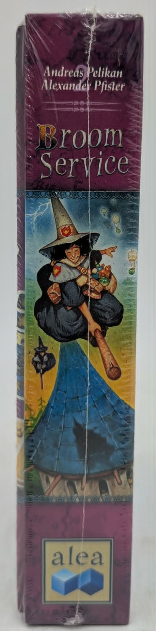 Ein Brettspiel-Cover zeigt eine Hexe im Flug, die einen Besen und einen Korb voller Gegenstände hält.