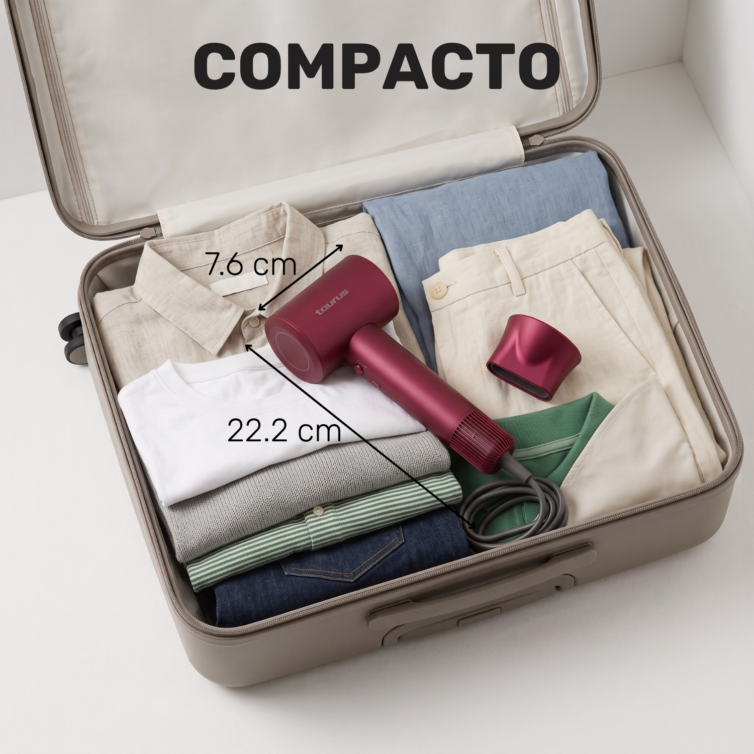 Un secador de pelo compacto en una maleta abierta con ropa.