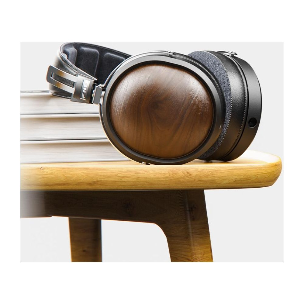 Auriculares con detalles de madera descansan sobre mesa de madera.