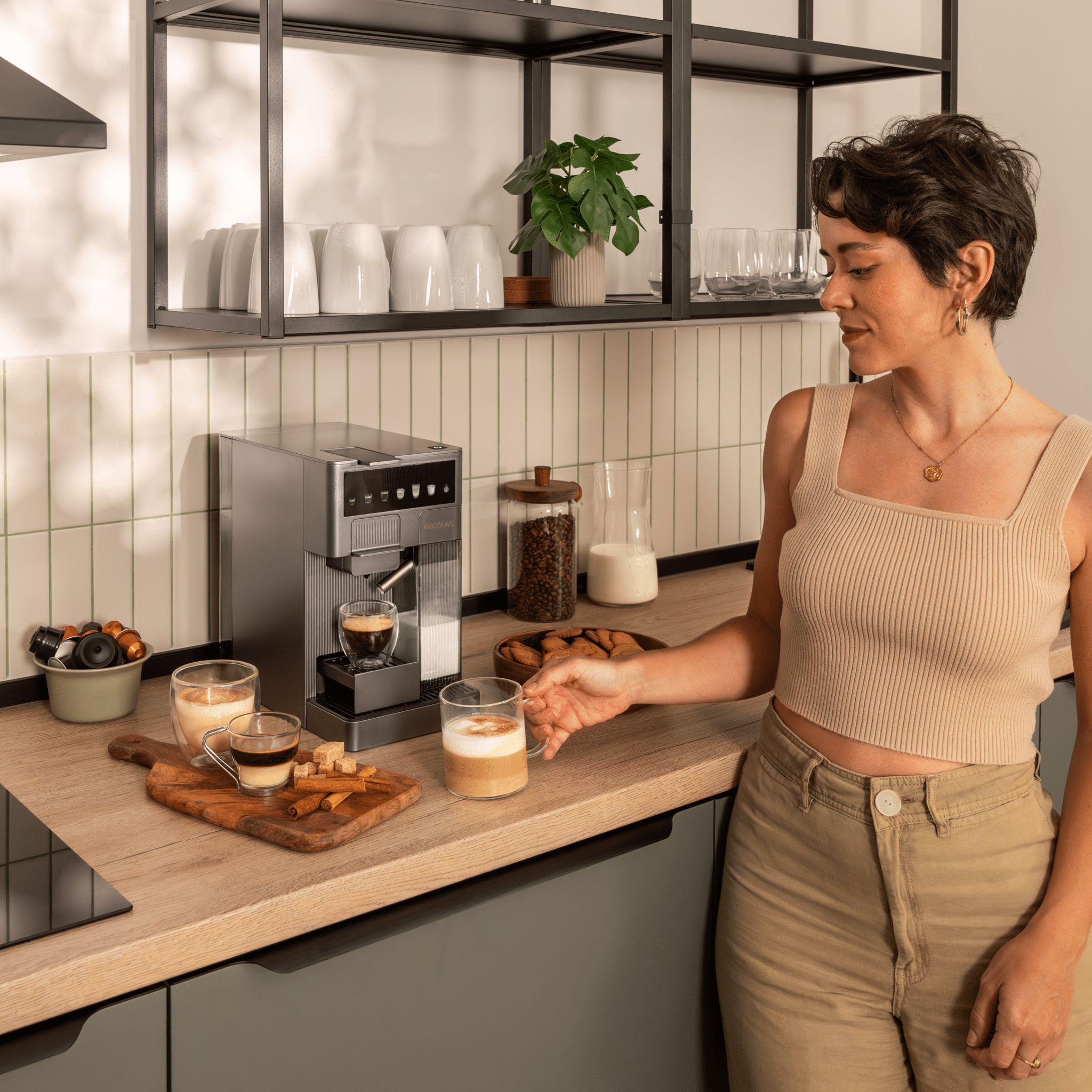 Una mujer en una cocina con máquina de café y bebidas de café.