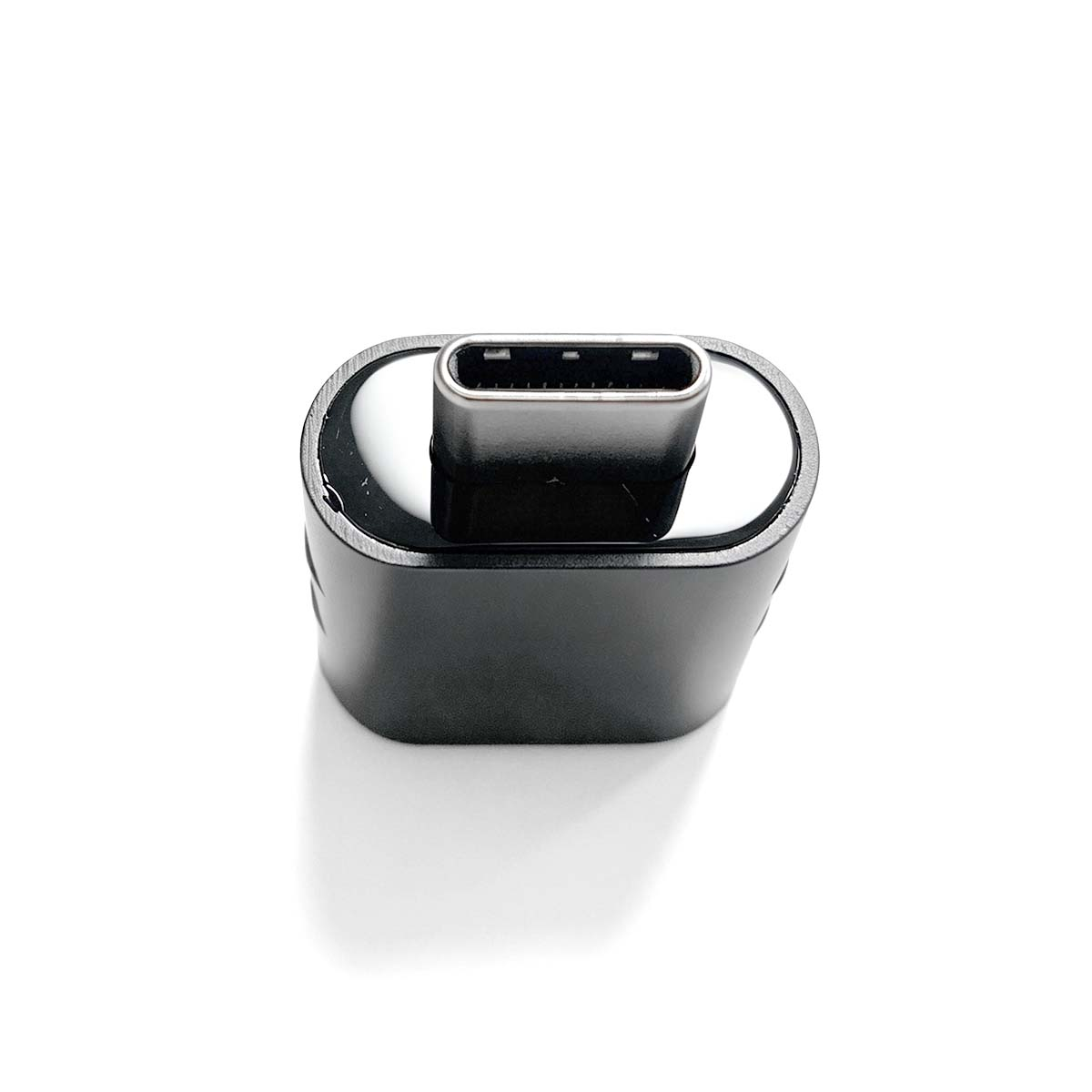 Ein schwarzer USB-C-Adapter mit silbernen Kontakten auf weißem Hintergrund.