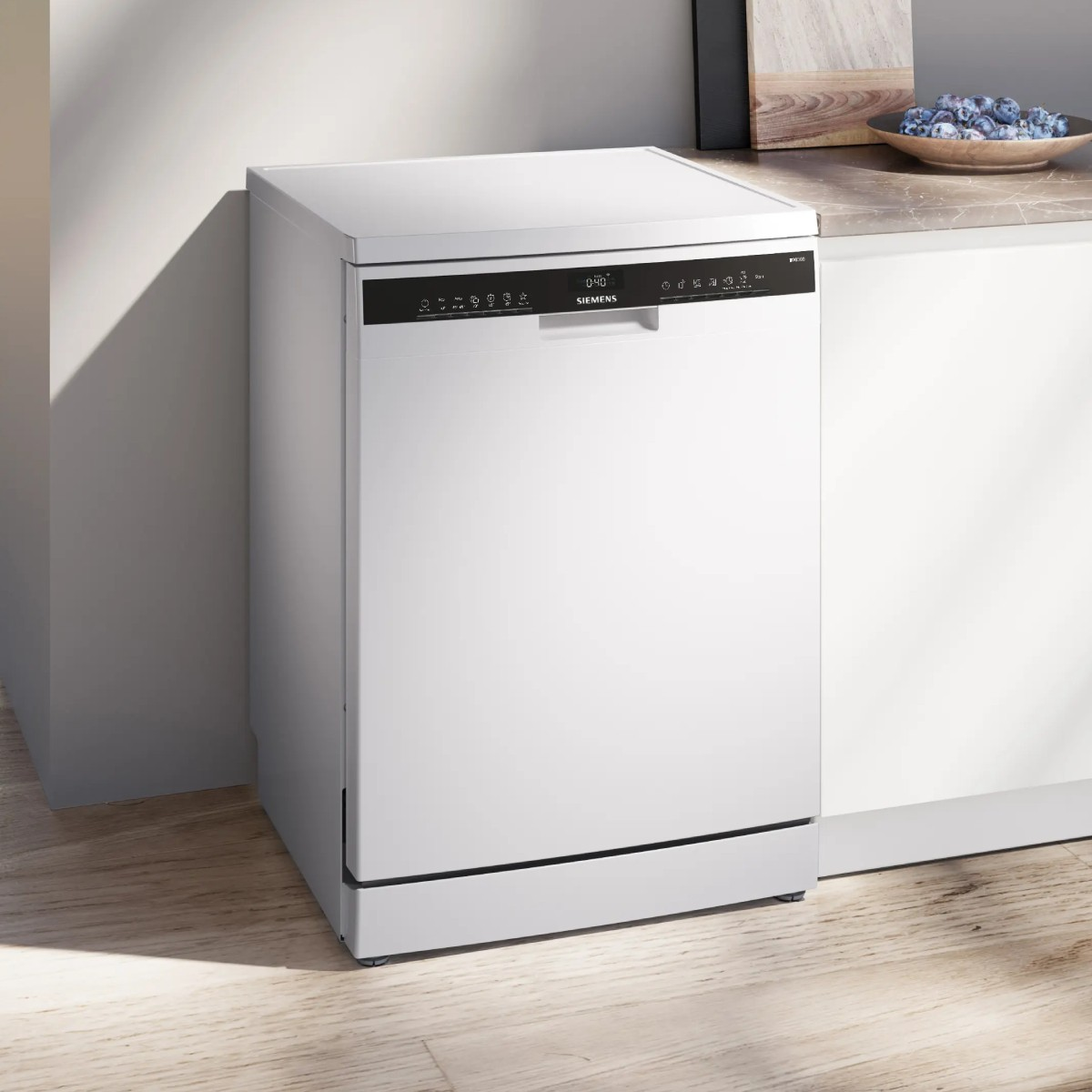 Una lavastoviglie Siemens bianca in una cucina con pavimento in legno.
