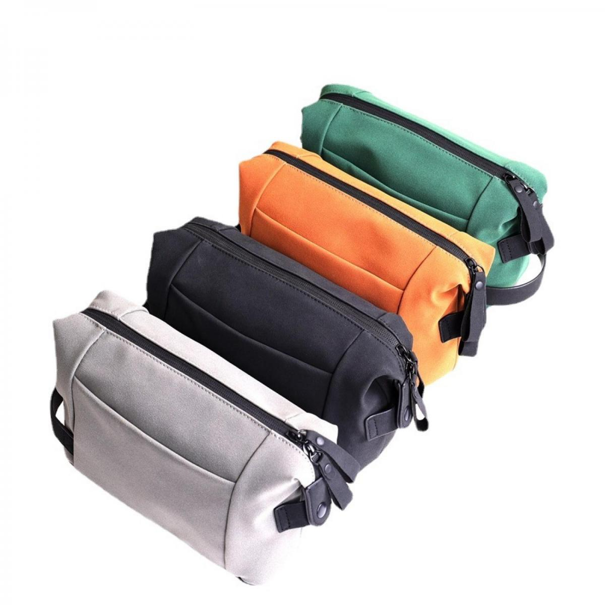 Vier Kulturtaschen in Grau, Schwarz, Orange und Grün auf weißem Hintergrund.