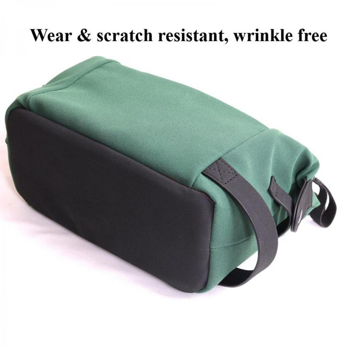 Eine grüne Tasche mit schwarzem Boden und schwarzen Riemen auf weißem Hintergrund.