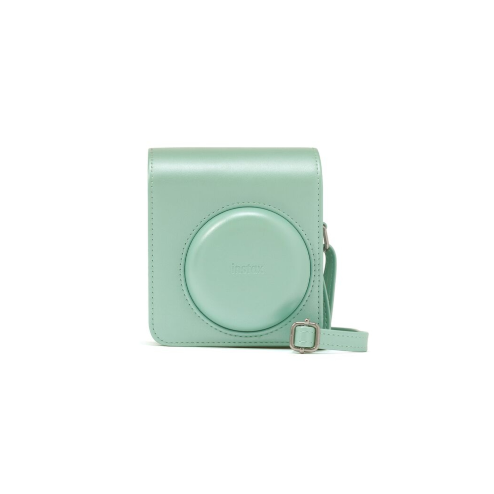 Un estuche de cámara verde menta con un panel frontal redondo con el relieve de Instax.