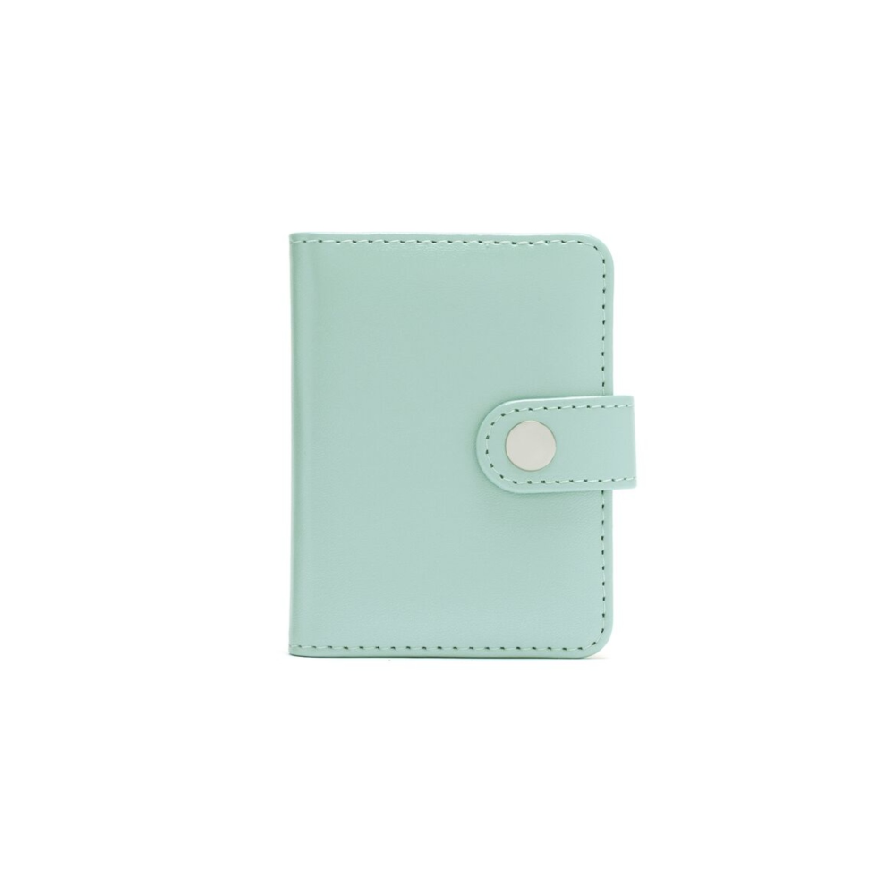 Un cuaderno verde claro con cierre de botón a presión sobre fondo blanco.