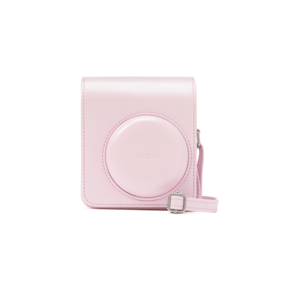 Una funda rosa claro para cámara Instax con correa y hebilla plateada. La funda tiene un recorte circular.