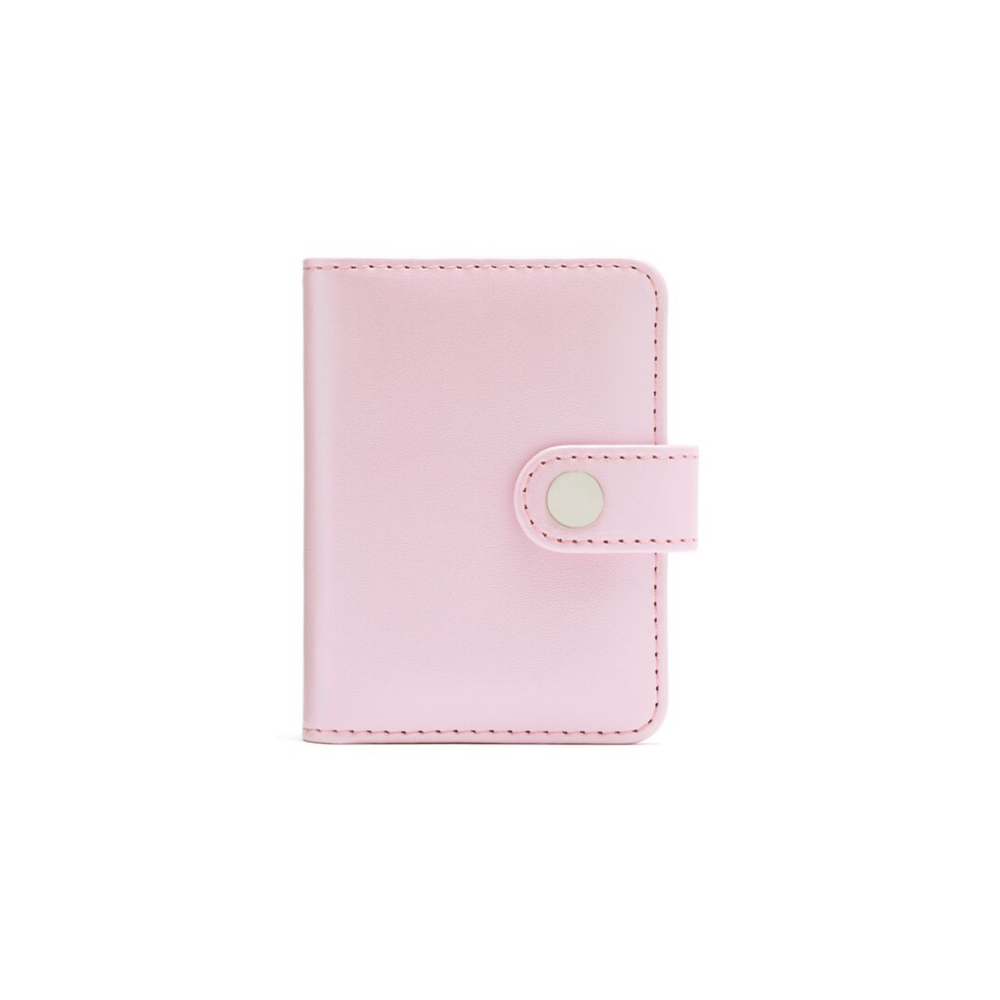 Un pequeño cuaderno rosa claro con cierre de botón a presión.