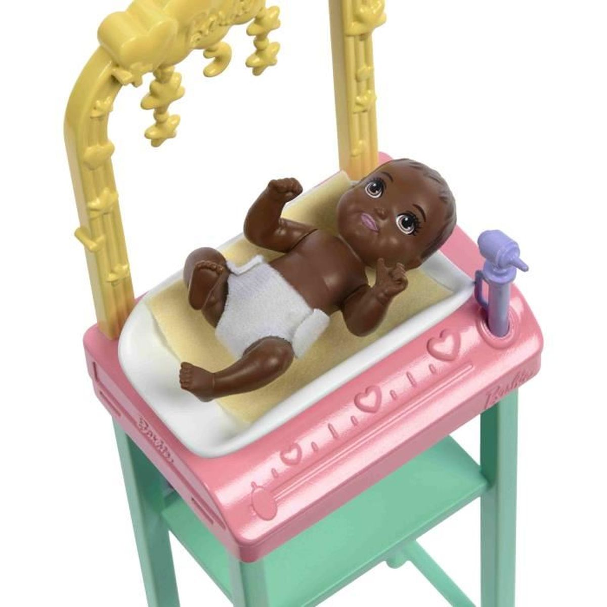 Een donkerhuidige baby met luier ligt in een wieg met mobiel.