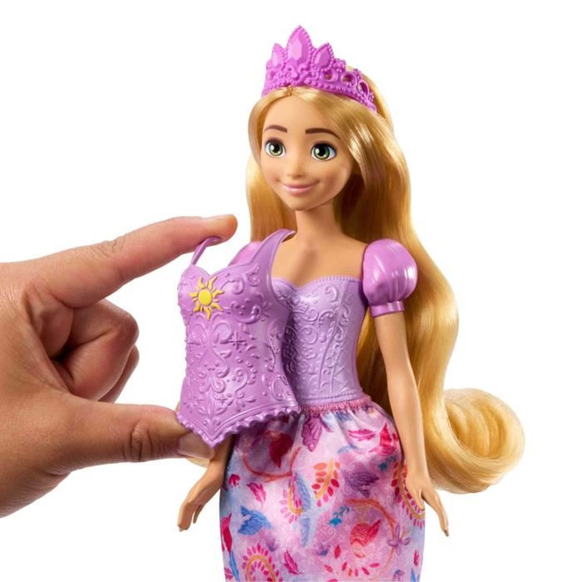 Een close-up van een pop met lang blond haar, een paarse jurk en een kroon. Een hand houdt er een paars lijfje naast.