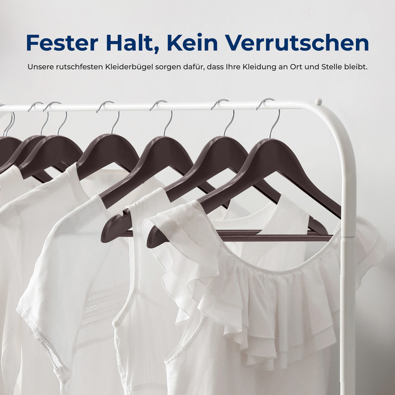 Dunkle Kleiderbügel mit weißen Kleidungsstücken auf einem Kleiderständer.