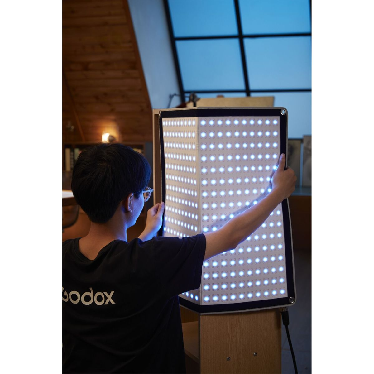 Person mit Brille stellt ein rechteckiges Lichtfeld mit vielen LEDs auf.