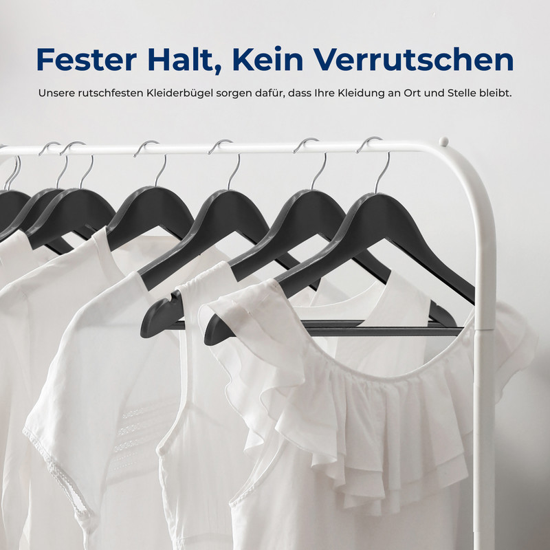 Mehrere weiße Kleidungsstücke hängen an schwarzen Kleiderbügeln auf einer Kleiderstange.
