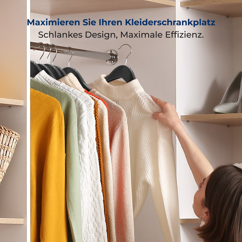 Eine Frau sortiert Kleidung in einem Kleiderschrank mit mehreren Pullovern an Kleiderbügeln.