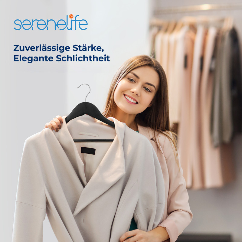 Eine Frau hält einen beigefarbenen Mantel vor sich, im Hintergrund Kleiderbügel.