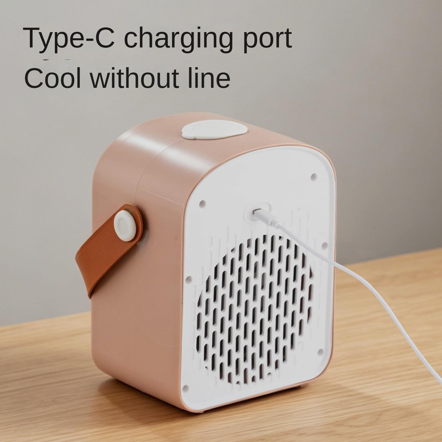 Ein roségoldener und weißer tragbarer Mini-Luftkühler mit braunem Griff, der über ein weißes Typ-C-Kabel auf einem Holztisch geladen wird.