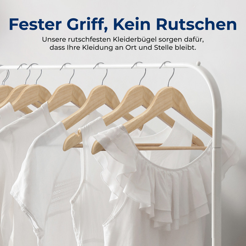 Weiße Kleidungsstücke hängen an Holz-Kleiderbügeln an einer Garderobe.