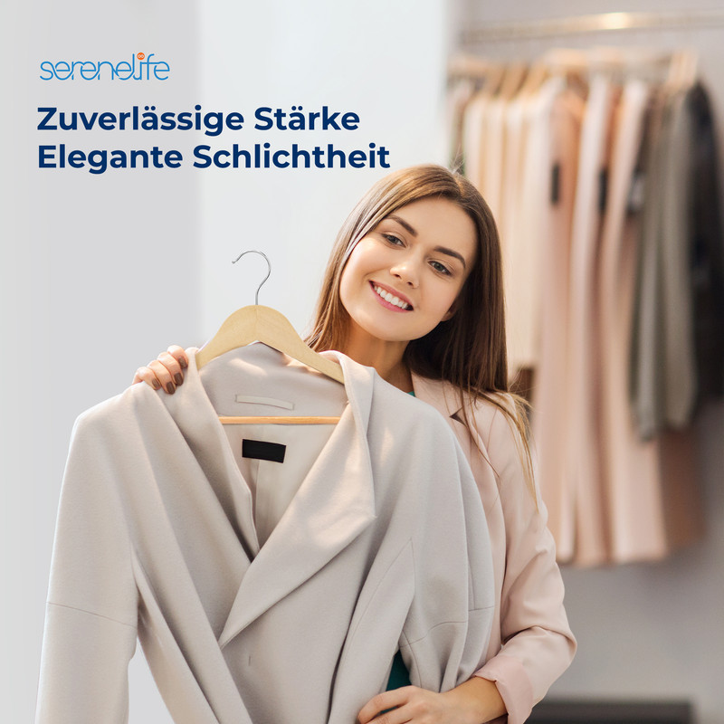 Eine Frau hält einen beigen Mantel vor sich, Kleiderständer im Hintergrund.