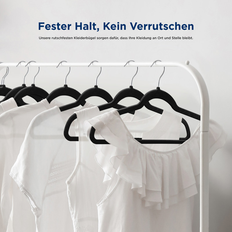 Weiße Kleidungsstücke hängen an schwarzen Kleiderbügeln auf einer Kleiderstange.