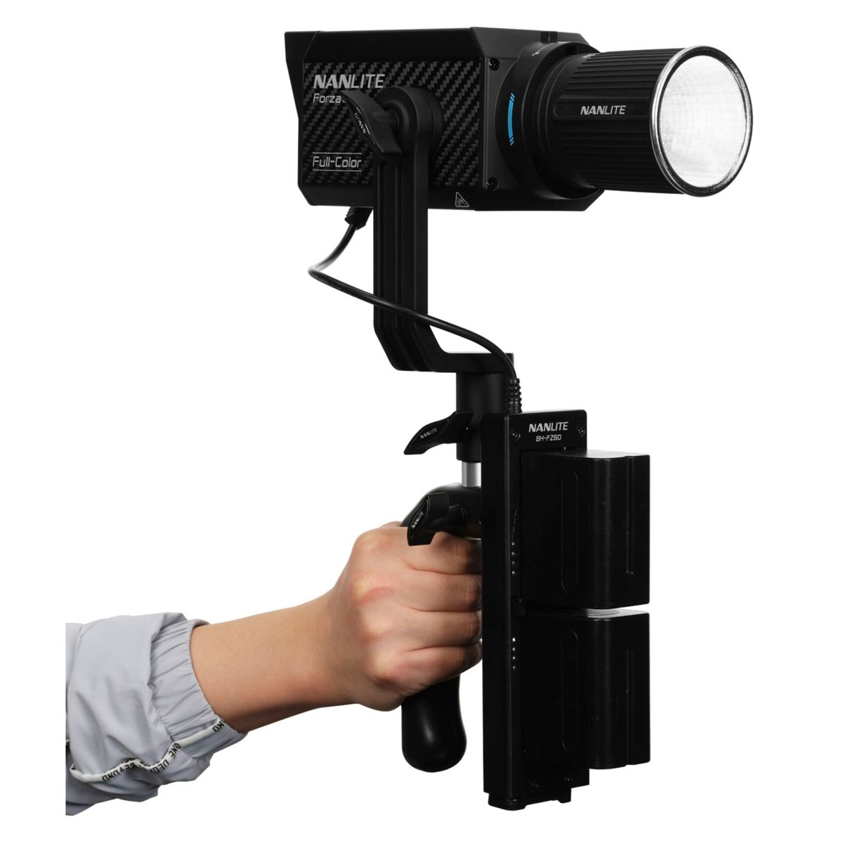 Hand hält Nanlite Forza-Leuchte mit Akkupack und Linse.