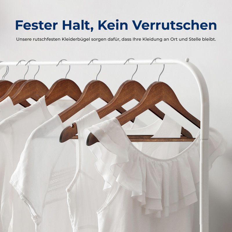 Holzbügel mit weißen Kleidungsstücken hängen an einem Kleiderständer.