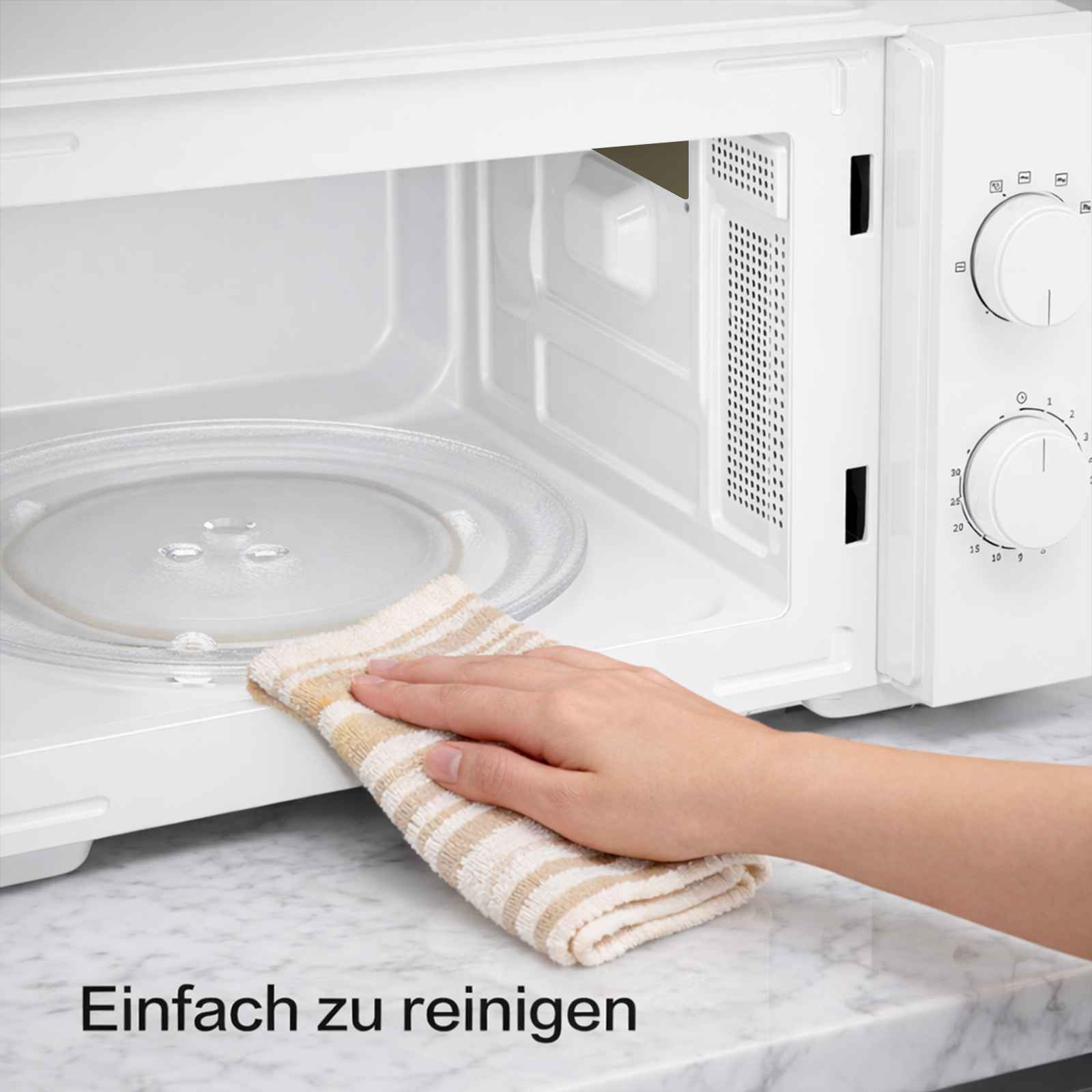 Eine Hand mit einem gestreiften Tuch reinigt die Mikrowelle.