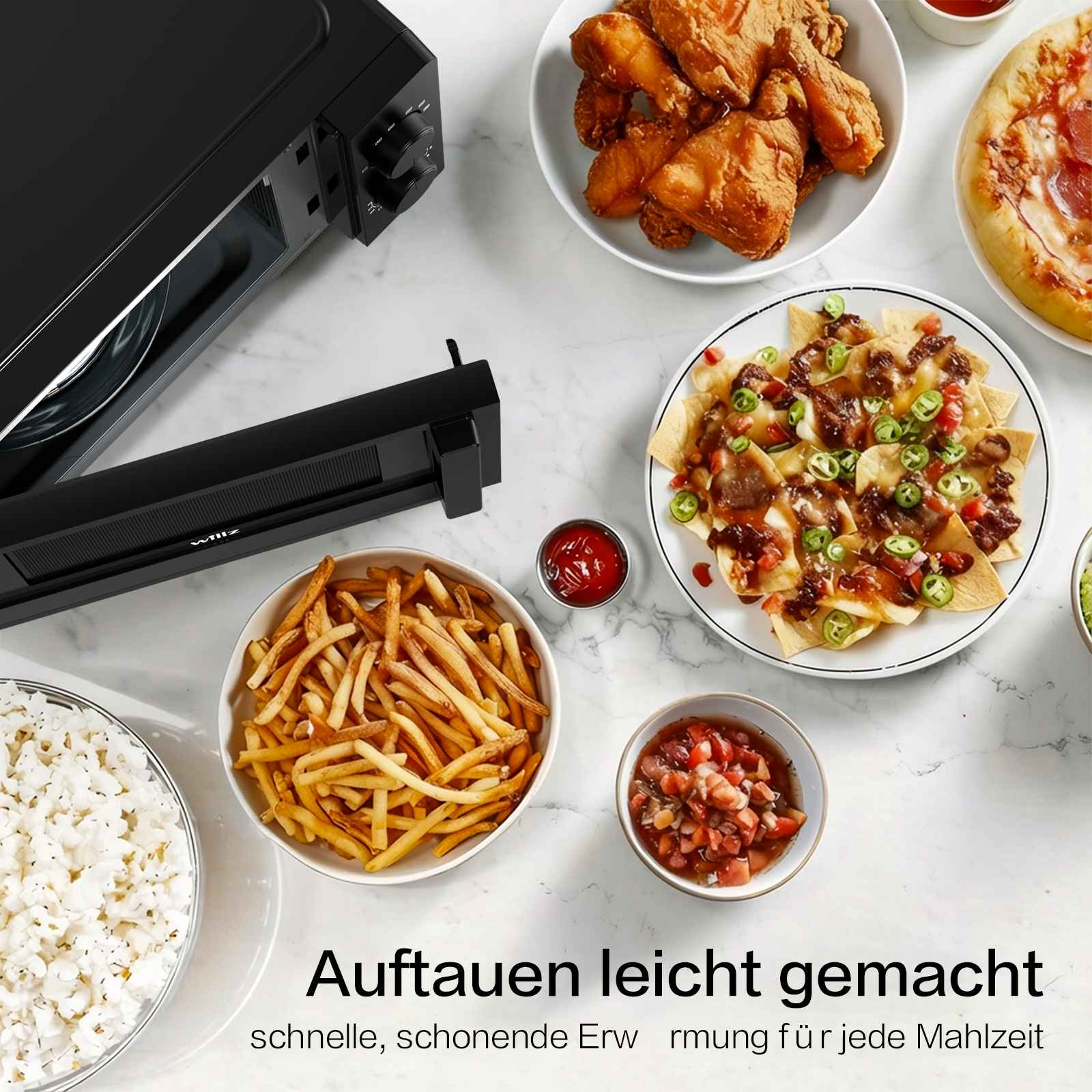 Ein schwarzer Ofen mit Hähnchen, Pizza, Pommes, Reis und Nachos.