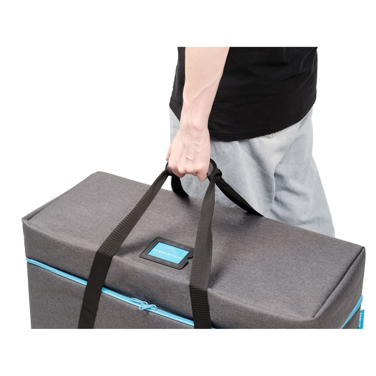 Graue Tasche mit blauen Akzenten, von einer Person an einem Griff getragen.