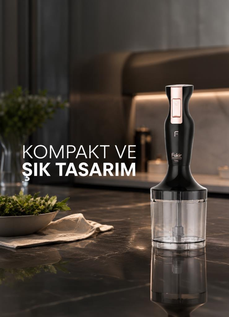 Rose gold detaylı siyah el blenderı, yeşillik kasesinin yanında mermer tezgahta duruyor.