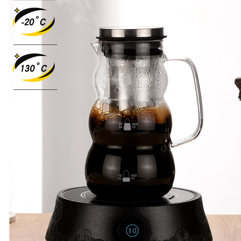 Glas-Kaffeekaraffe mit Metallfilter auf einer Heizplatte, daneben Temperaturschilder.