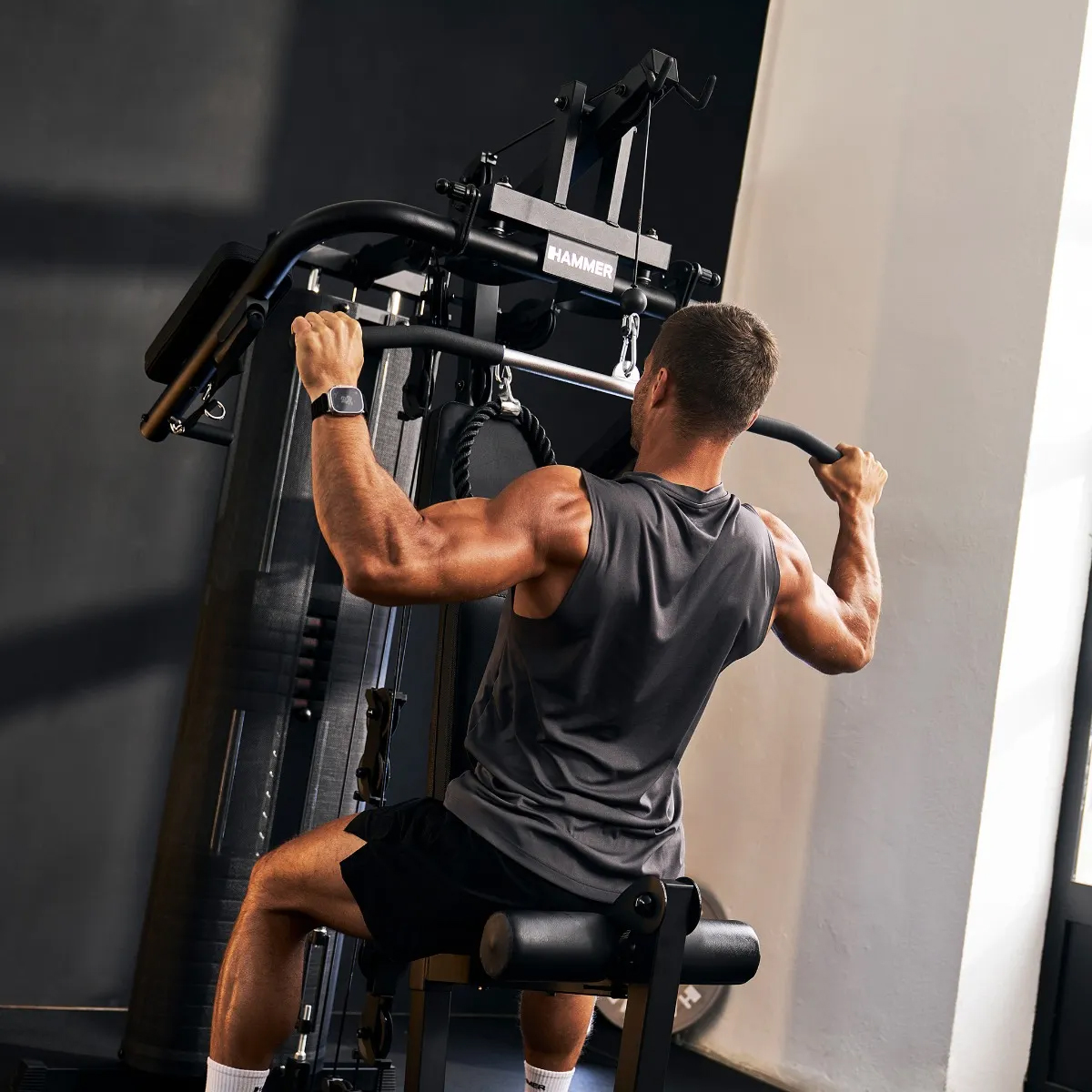 Mann trainiert Rücken an einer Latzugmaschine im Fitnessstudio.