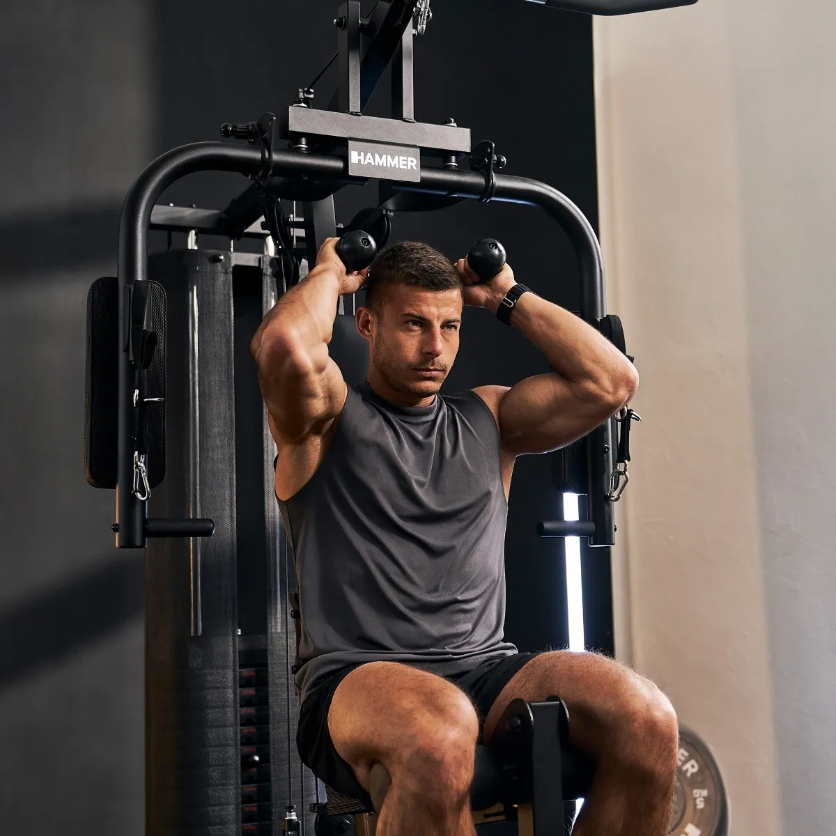 Ein Mann trainiert seine Arme an einem Fitnessgerät im Fitnessstudio.