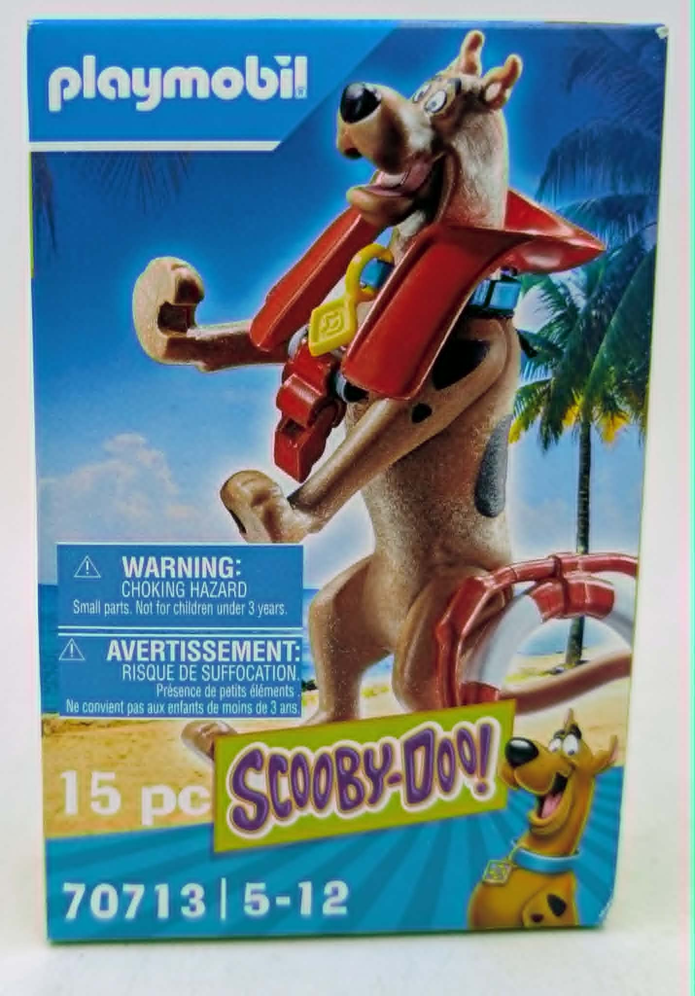 Playmobil-Verpackung mit Scooby-Doo-Figur am Strand, Palmen im Hintergrund.