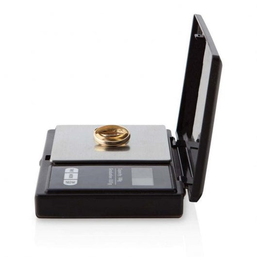 Un anillo de oro descansa sobre una báscula digital. La báscula está abierta.