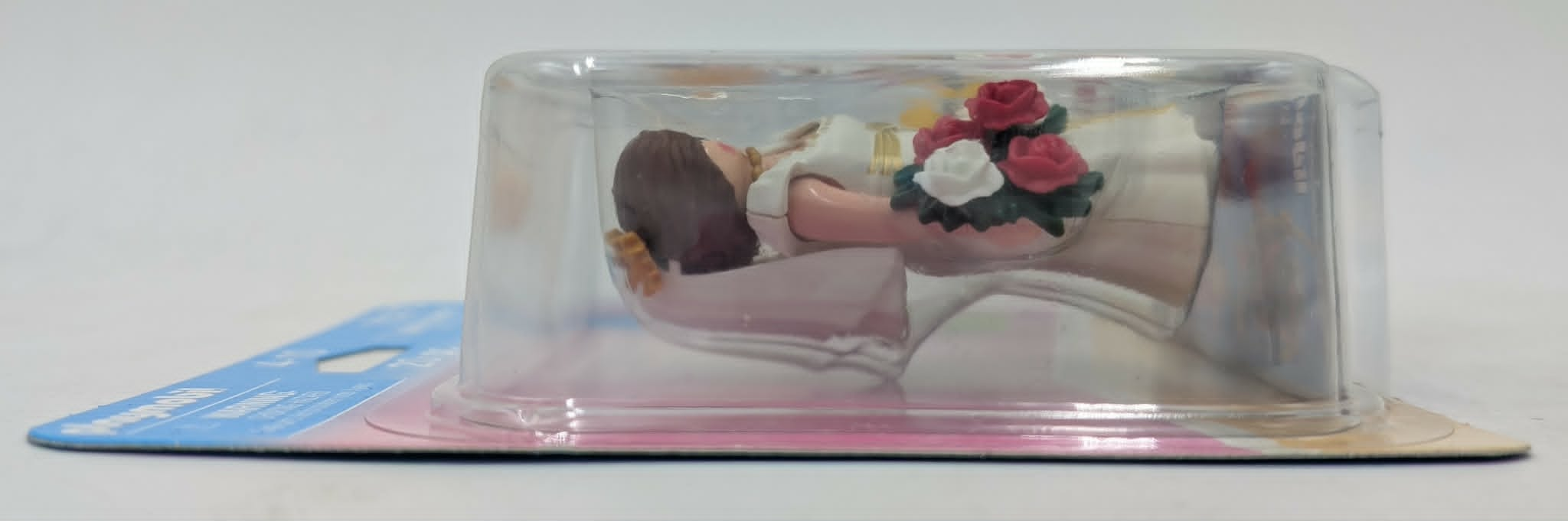 Una figura Playmobil di sposa in abito bianco con bouquet in un display di plastica.