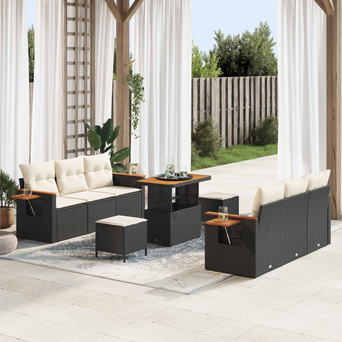 Dunkelgraues Rattan-Sofa-Set mit cremefarbenen Kissen auf einer Terrasse.