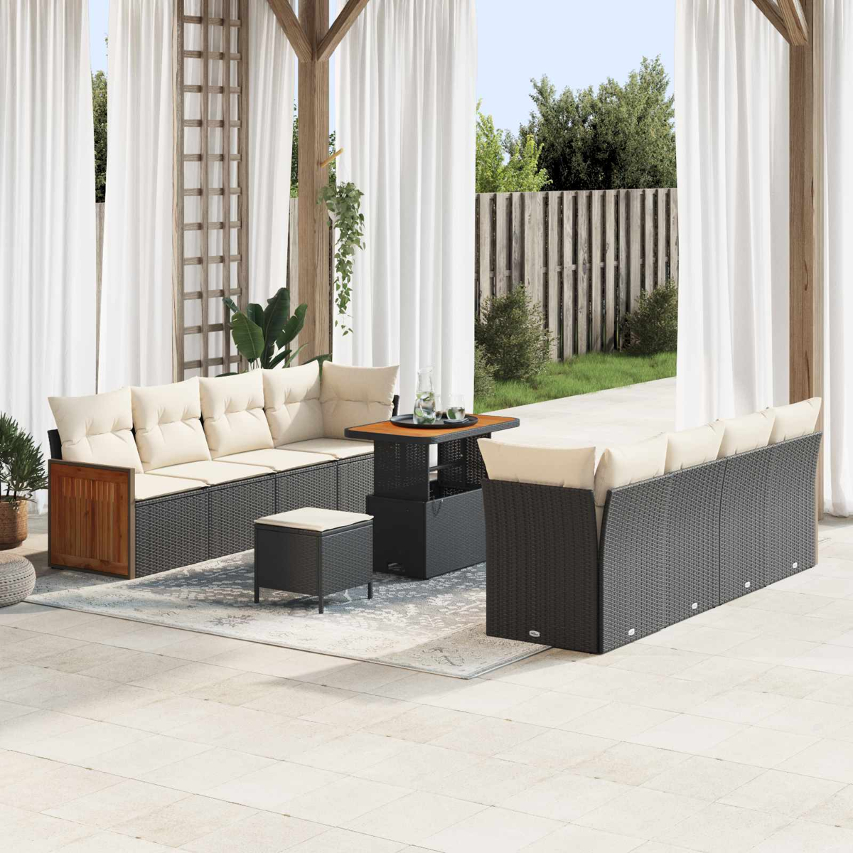 Mobiliario de salón de ratán gris oscuro con cojines beige claro en un patio.