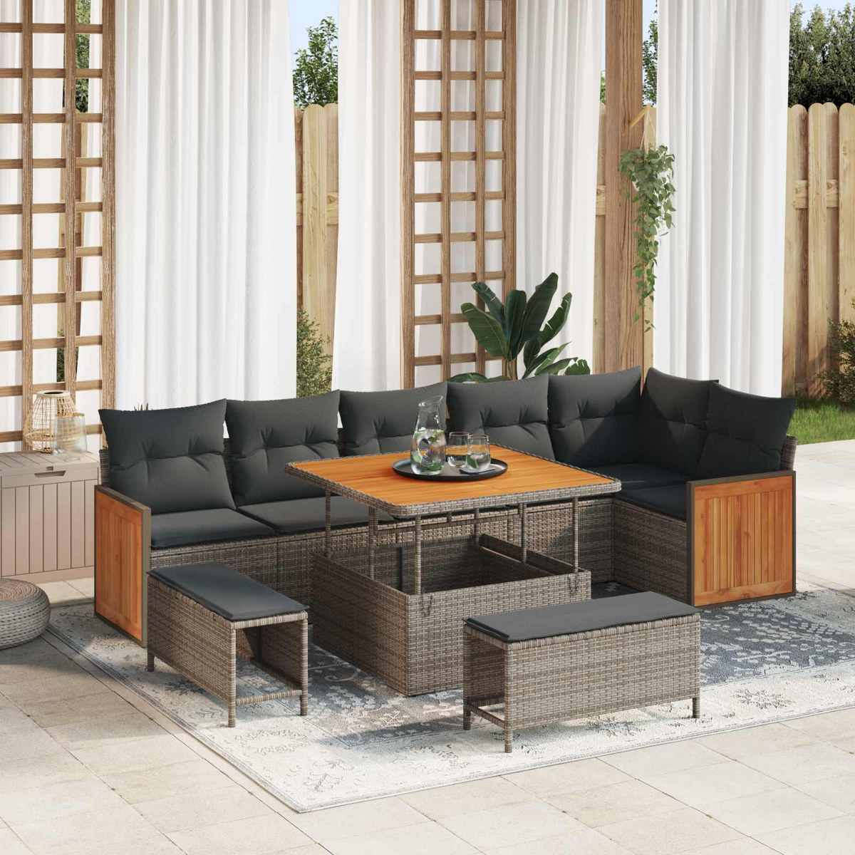 Conjunto de salón exterior con ratán gris, detalles en madera y cojines negros.