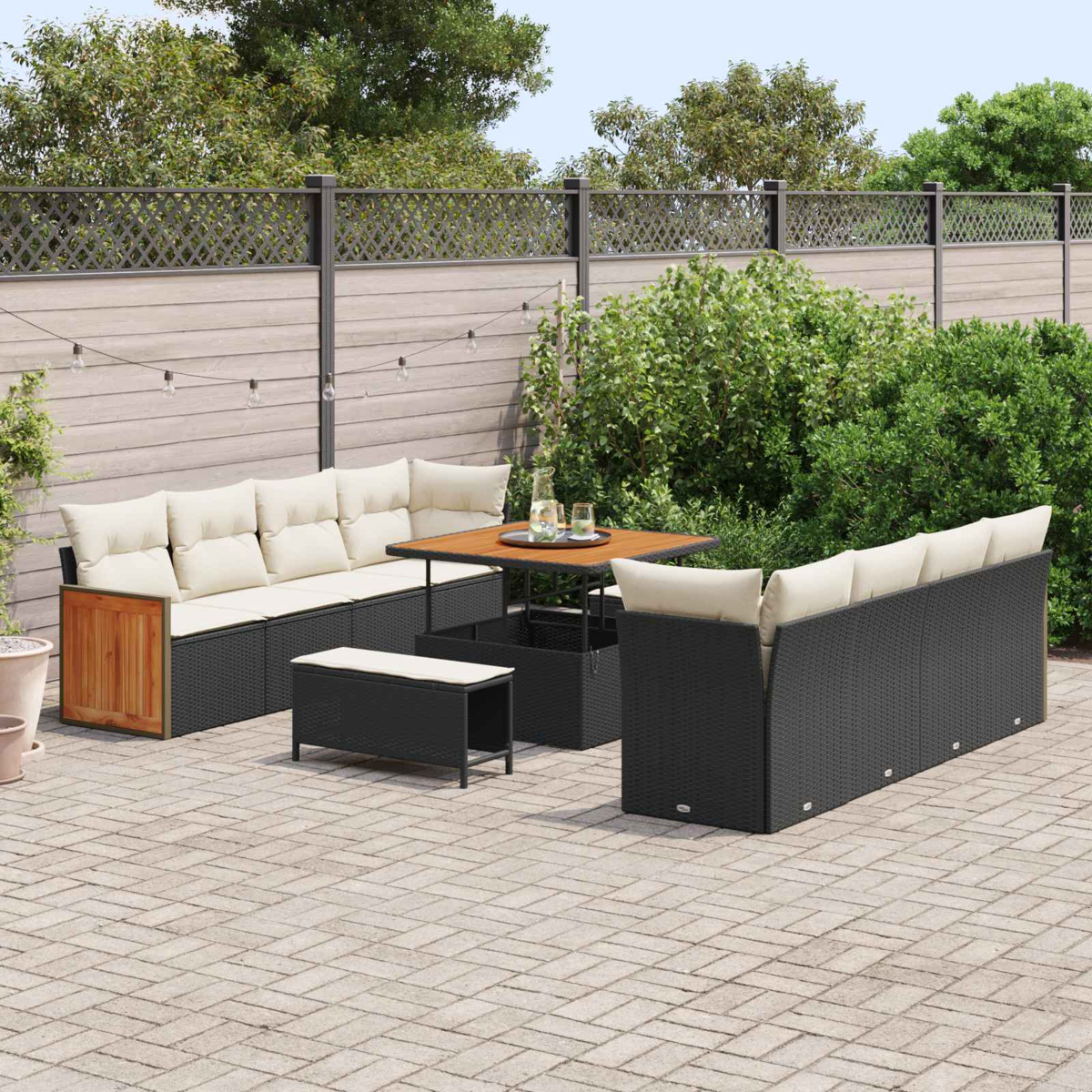 Rattan-Gartenmöbelgarnitur mit beigen Polstern auf gepflasterter Terrasse.