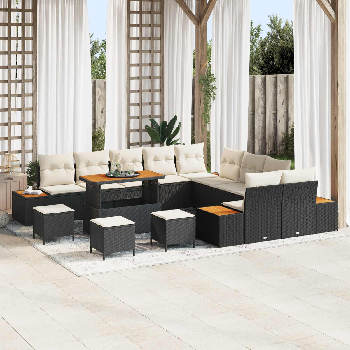 Un set da salotto in rattan nero con cuscini color crema e tavolo in legno.