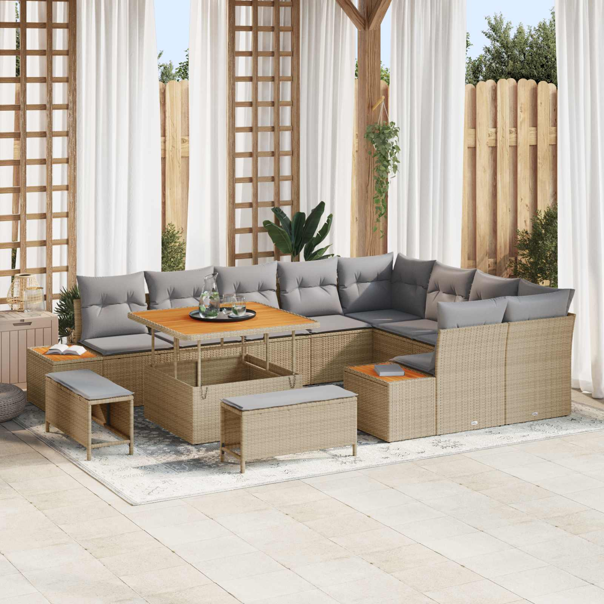 Geflochtene Lounge-Ecke mit grauen Kissen, Holztisch und Bänken.