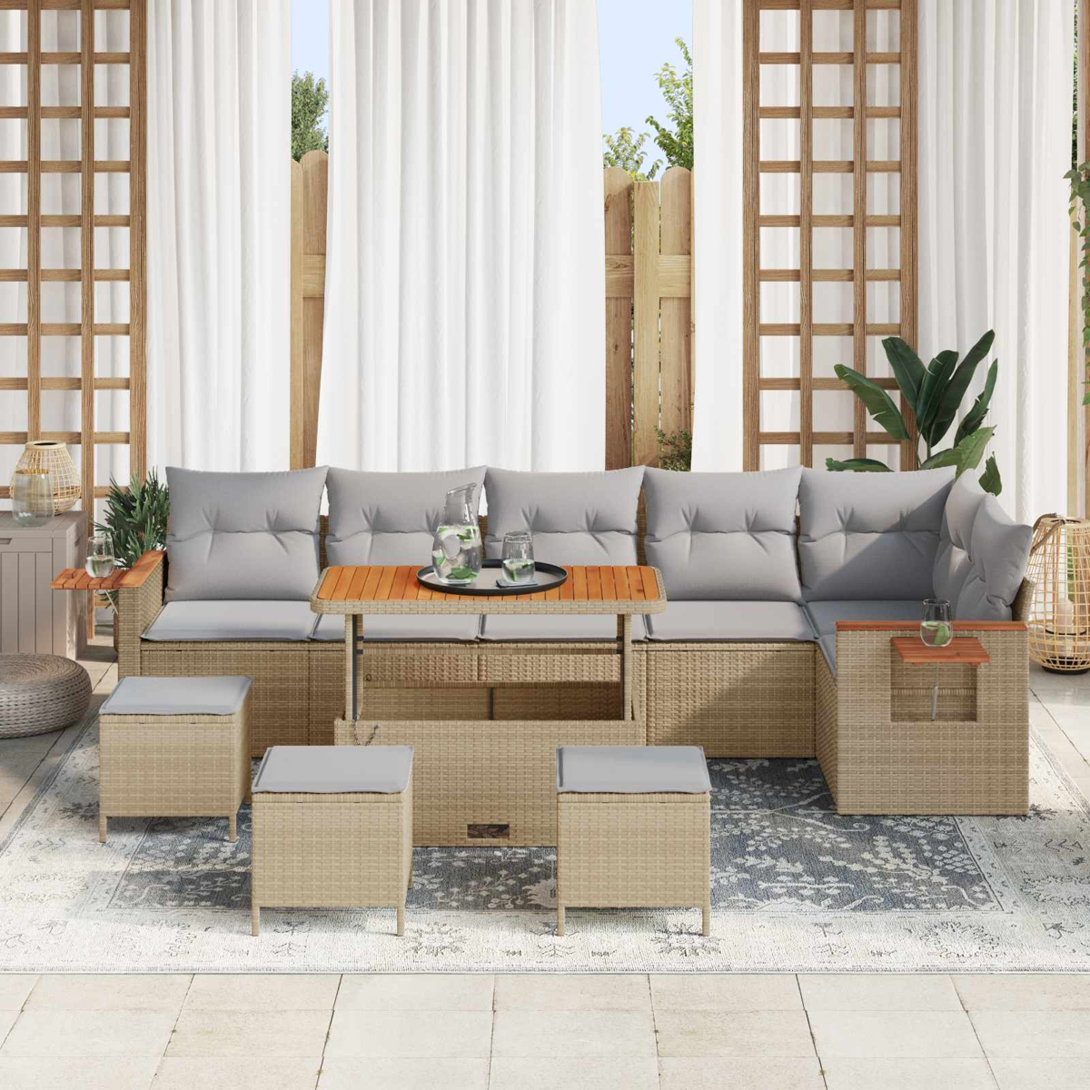 Un set di divani in rattan beige con cuscini grigi, tavolo in legno e pouf su un patio.