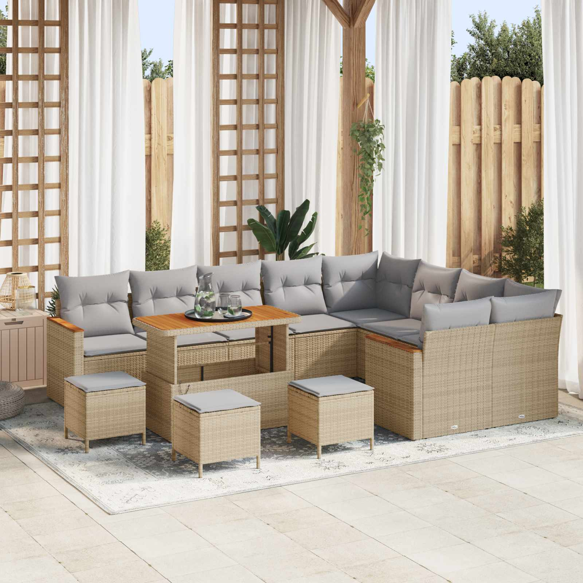 Beige Rattan-Lounge-Set mit grauen Kissen auf Veranda mit weißen Vorhängen.