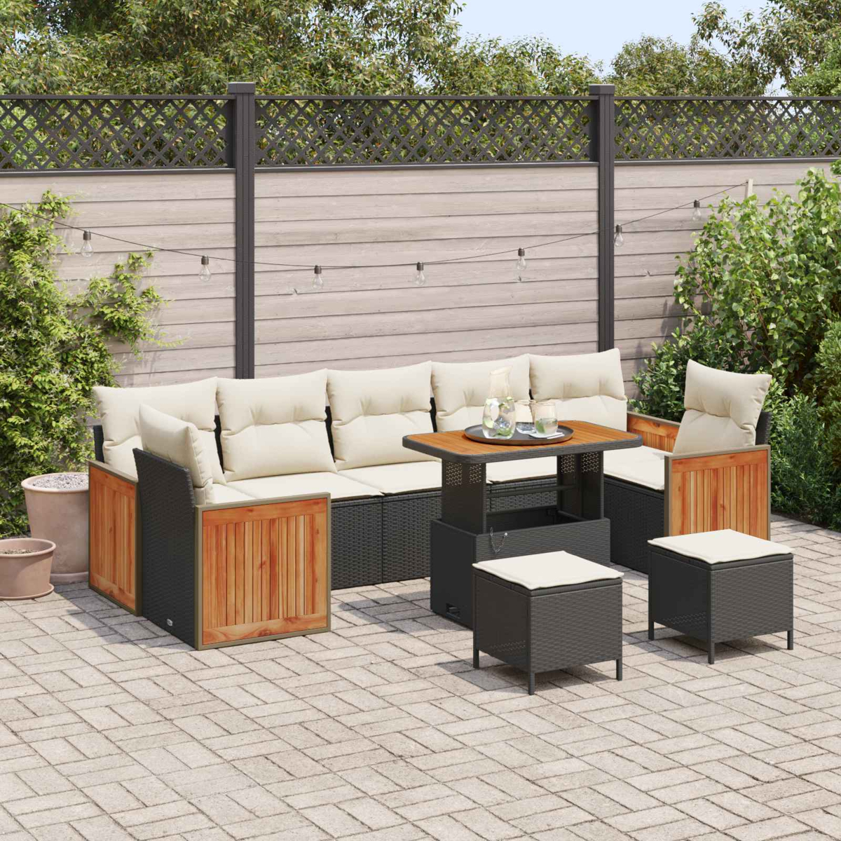 Salón de exterior con sofá, mesa y taburetes en un patio pavimentado.