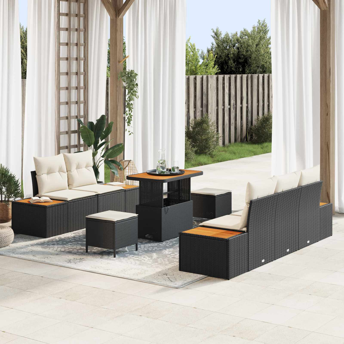 Dunkelgraue Rattan-Gartenmöbel mit beigen Kissen auf einer Terrasse.