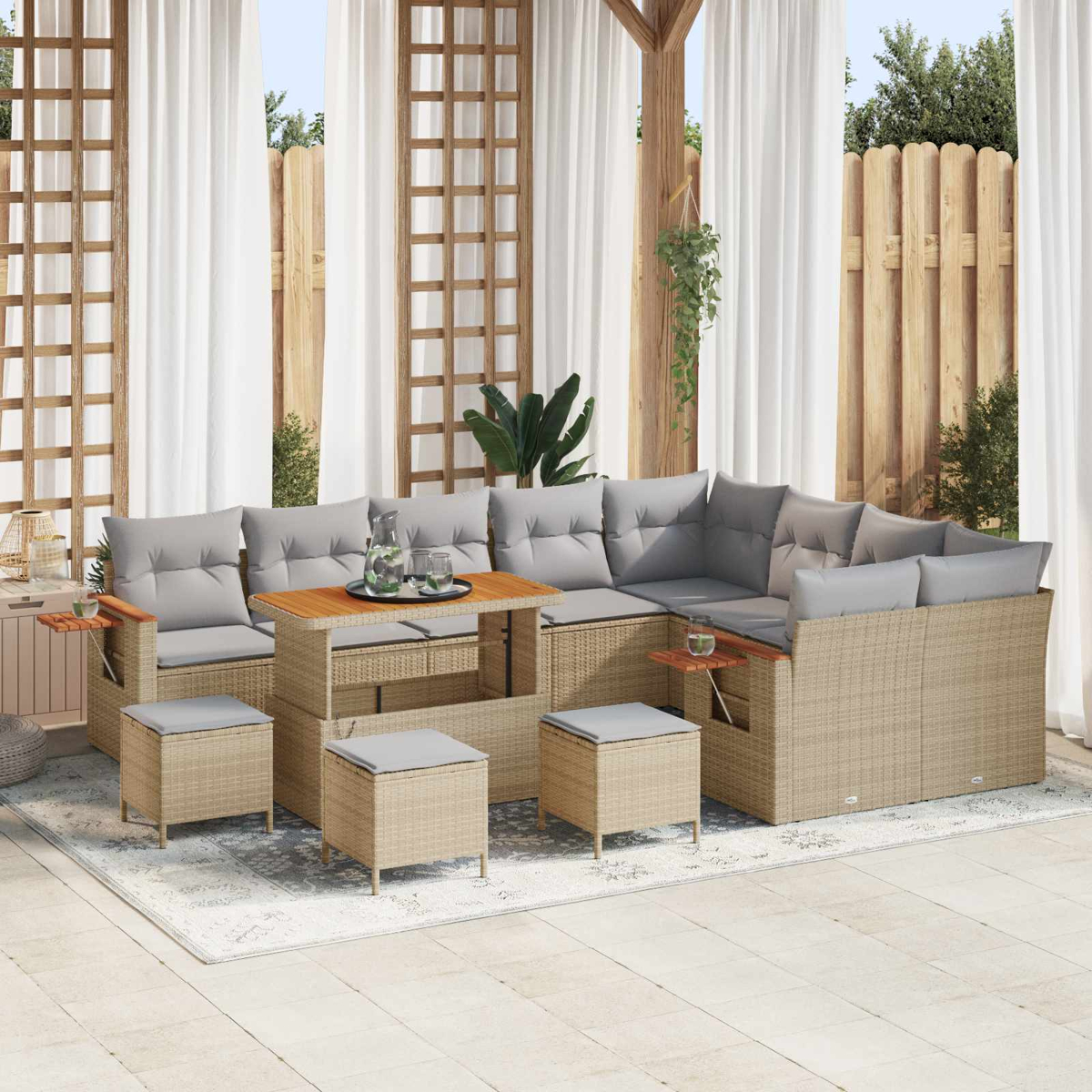 Ein beiger Rattan-Sofa-Set mit grauen Kissen und einem Holztisch auf einem Teppich im Freien.