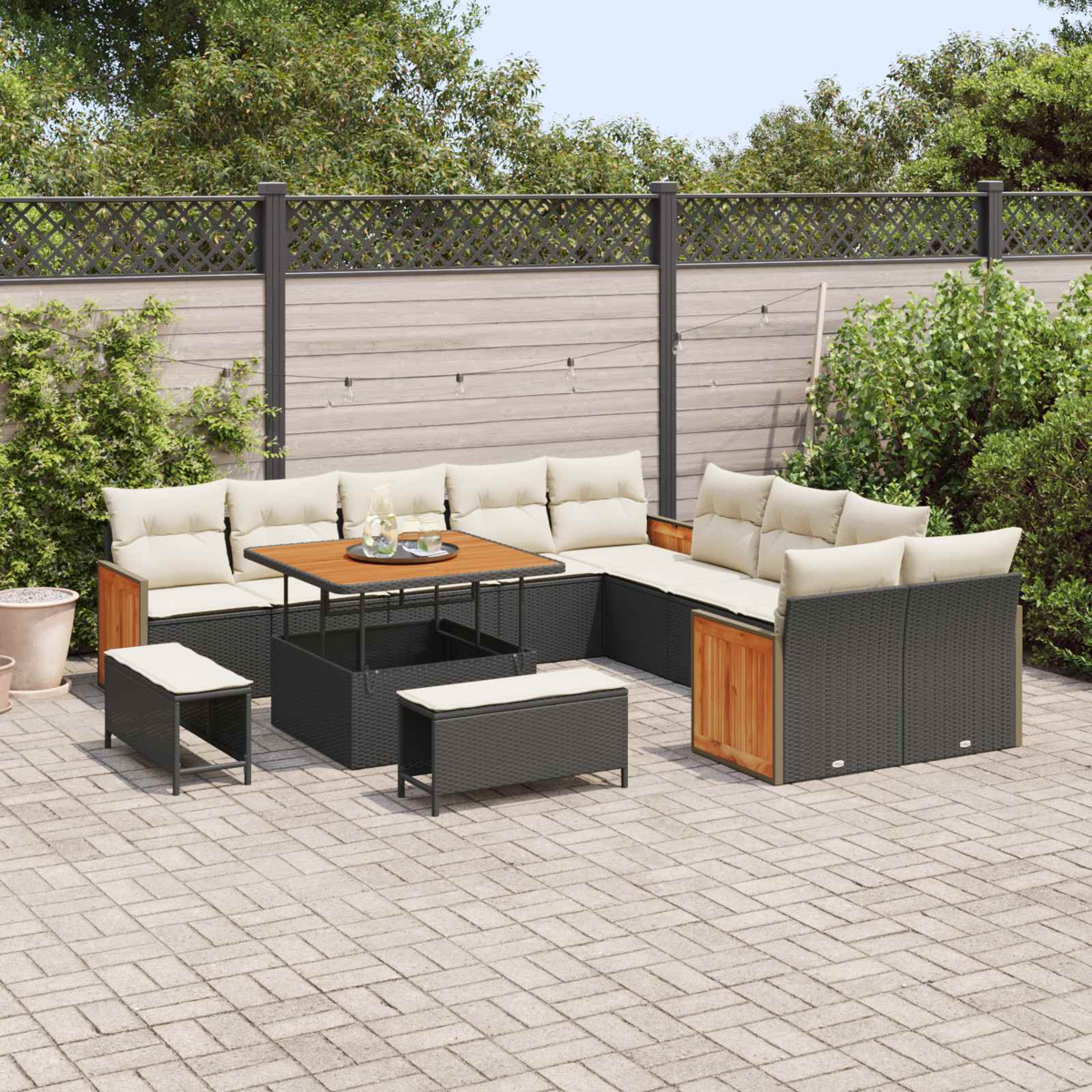 Un set di mobili da giardino con divano, tavolo e sgabelli su un patio pavimentato.