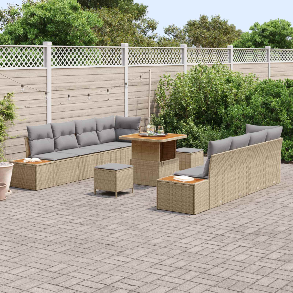 Salotto da esterno con cuscini grigi e tavolo su patio pavimentato.