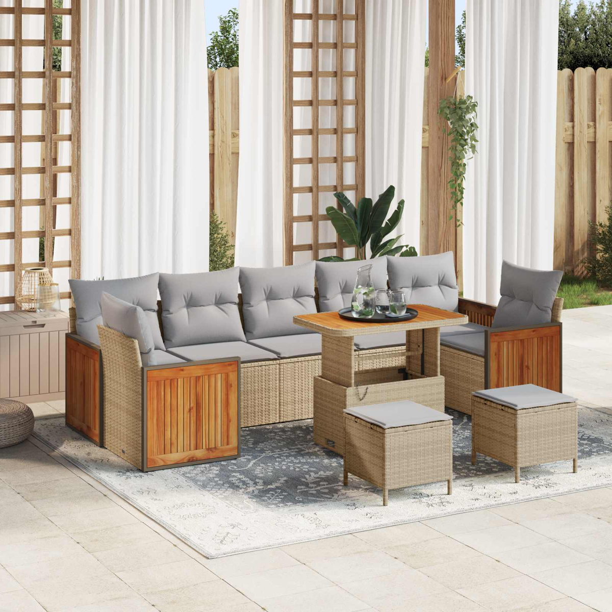 Geflochtene Outdoor-Lounge mit grauen Kissen und Holzakzenten, Tisch mit Gläsern.
